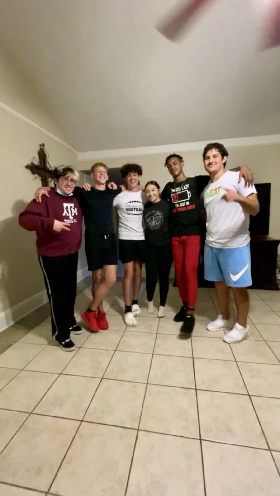 Jordan the quinceañera and her chambelanes posing in her living room after dance practice