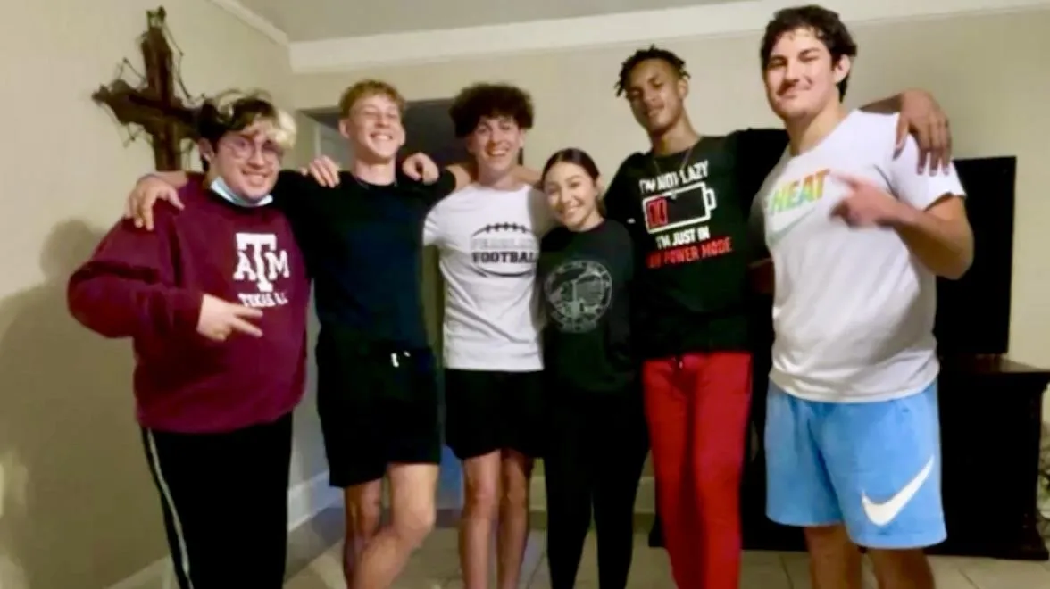 Jordan the quinceañera and her chambelanes posing in her living room after dance practice