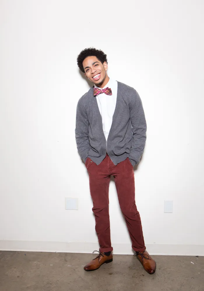 Micah Pushia smiling at the camera in a stylish outfit with a bowtie, founder of Quince Dance Academy