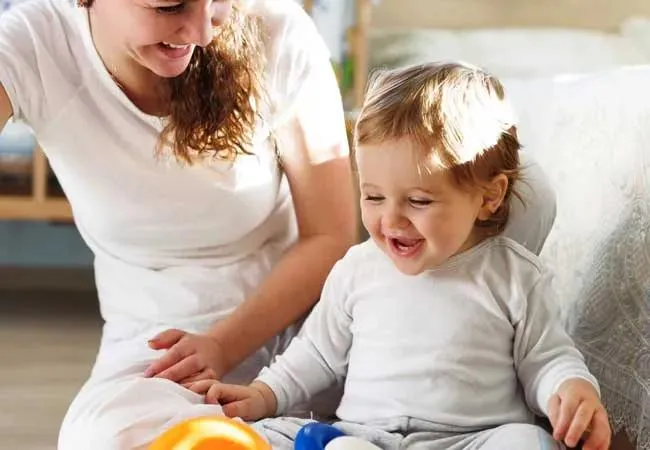 Loving teacher engaging in one-on-one tummy time with a baby at Sugar n Spice