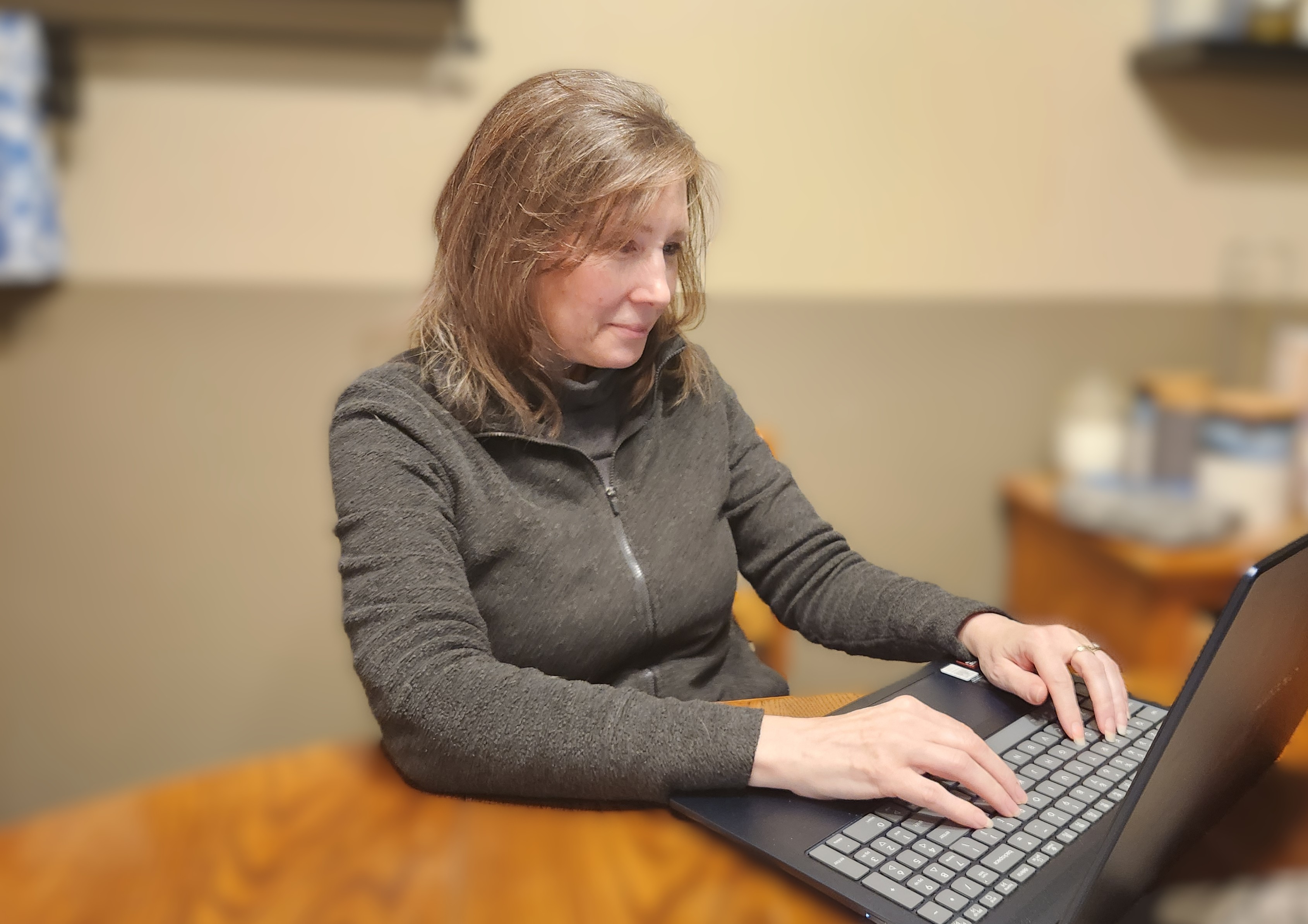 short-haired black cat besides brown wooden table
