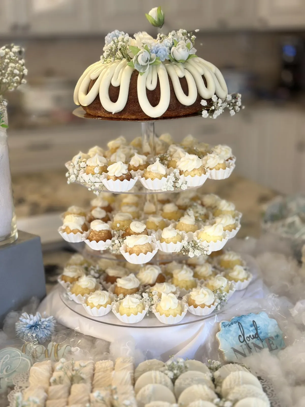 Floral bundt cake with white roses, baby's breath, and powder-blue florals.