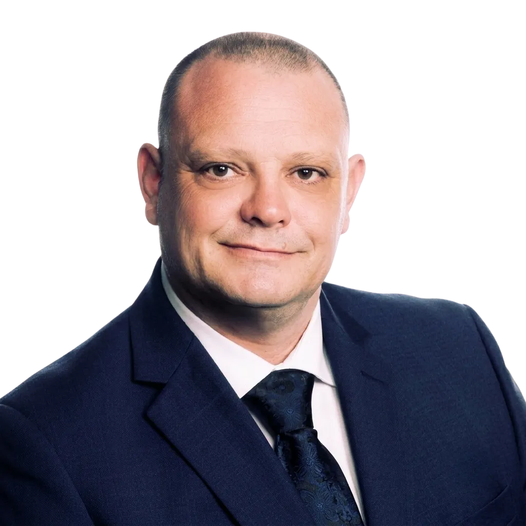 Andy Lewis, HSEQ, risk and governance executive, in a navy suit against a grey background