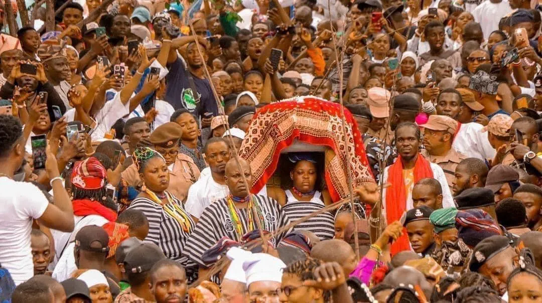 a field with trees and buildings in the background