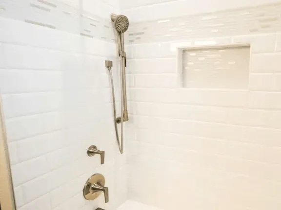 Remodeled bathroom in Rockville MD with modern fixtures, glass-enclosed shower, freestanding tub, and elegant decor.