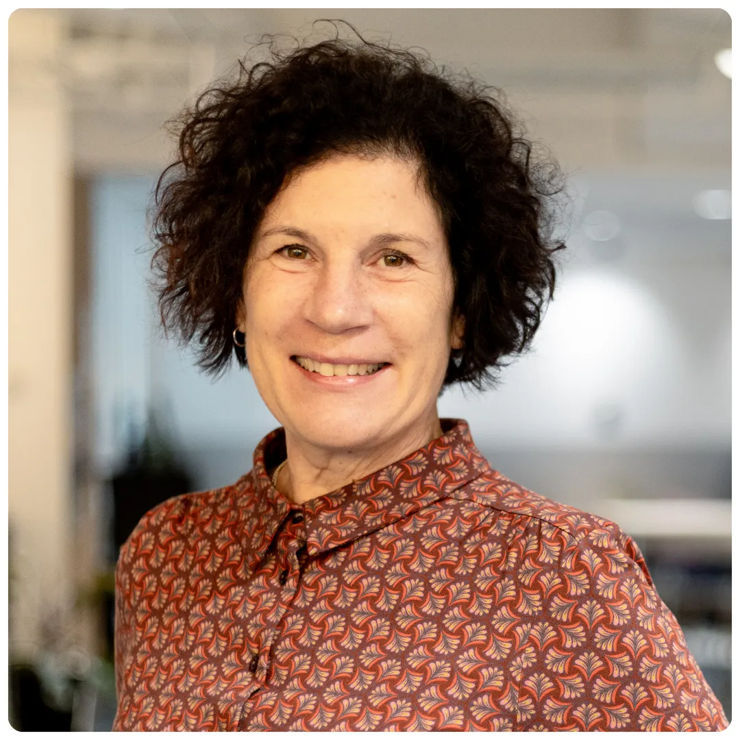 Ulrika Gill på Företagarbyrån står vänd mot kameran och ler. Hon har en rödmönstrad blus på sig.