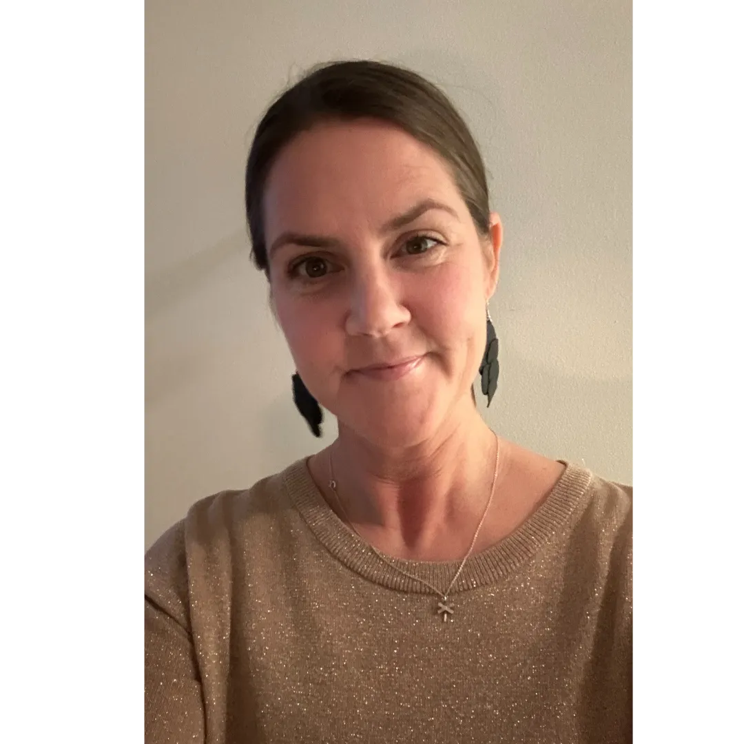 Onlineföretagaren Jessica Lindblad på Jes You Can står mot en beig bakgrund och ler mot kameran. Hon har en brunglittrig tröja på sig och mörka örhängen som hänger ner.