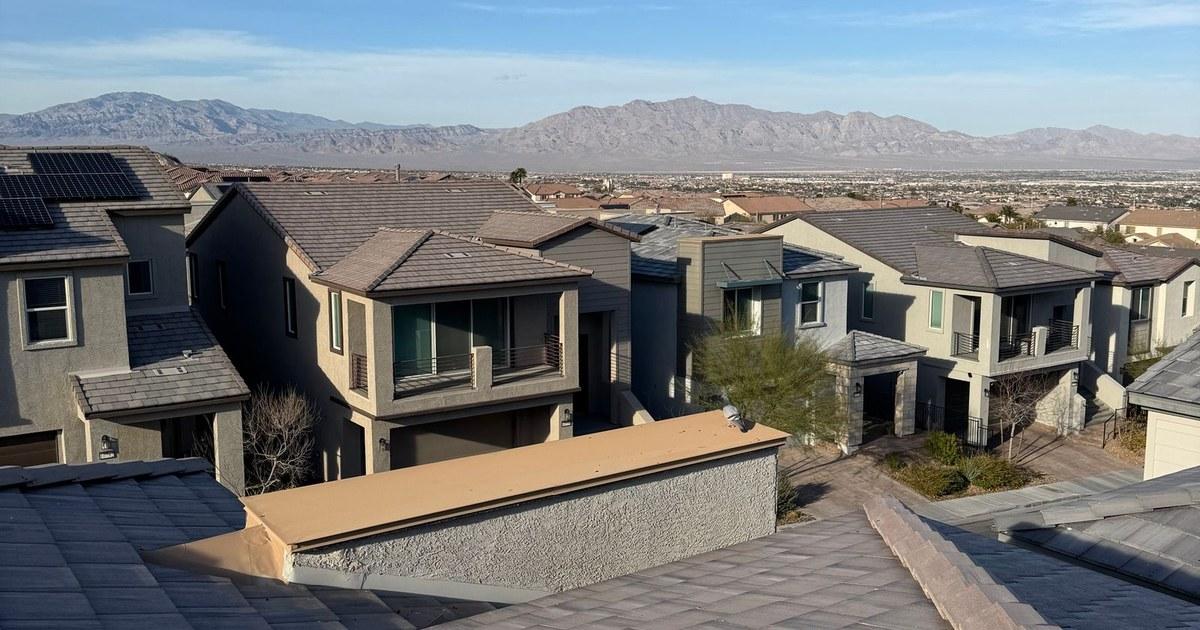 Rooftops of two-story homes in a Las Vegas neighborhood with mountains in the distance