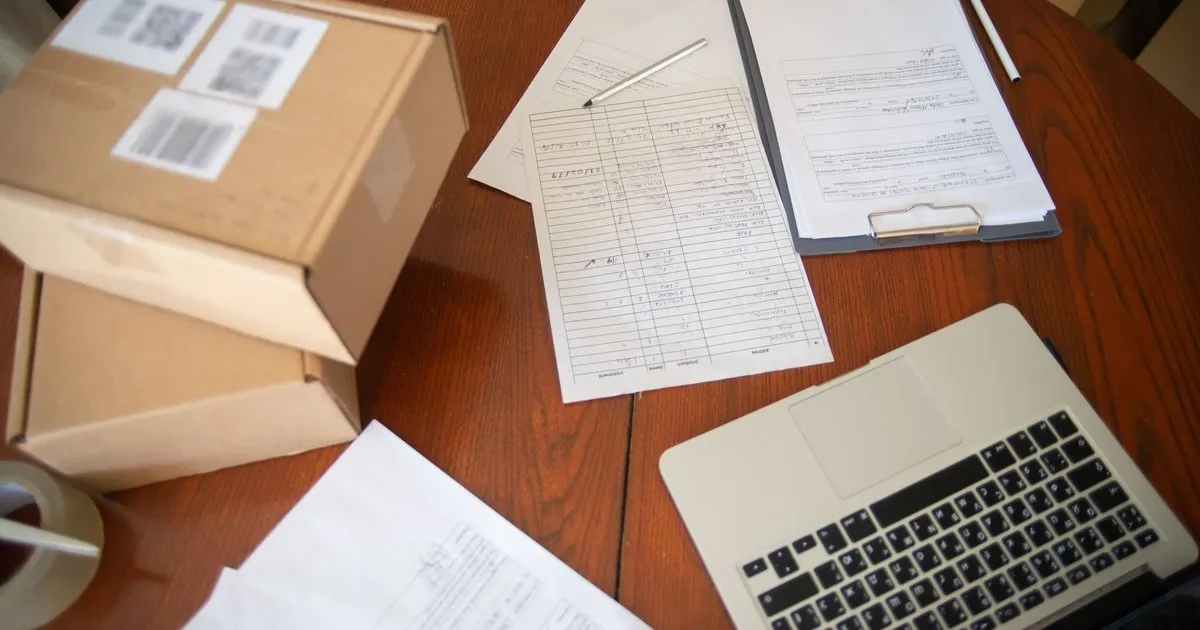 Flat lay of paperwork and a laptop on a wooden table