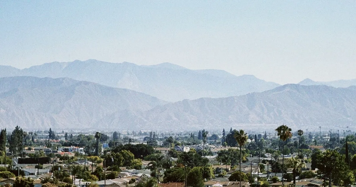 Rooftops of a suburban neighborhood with a mountain range in the distance