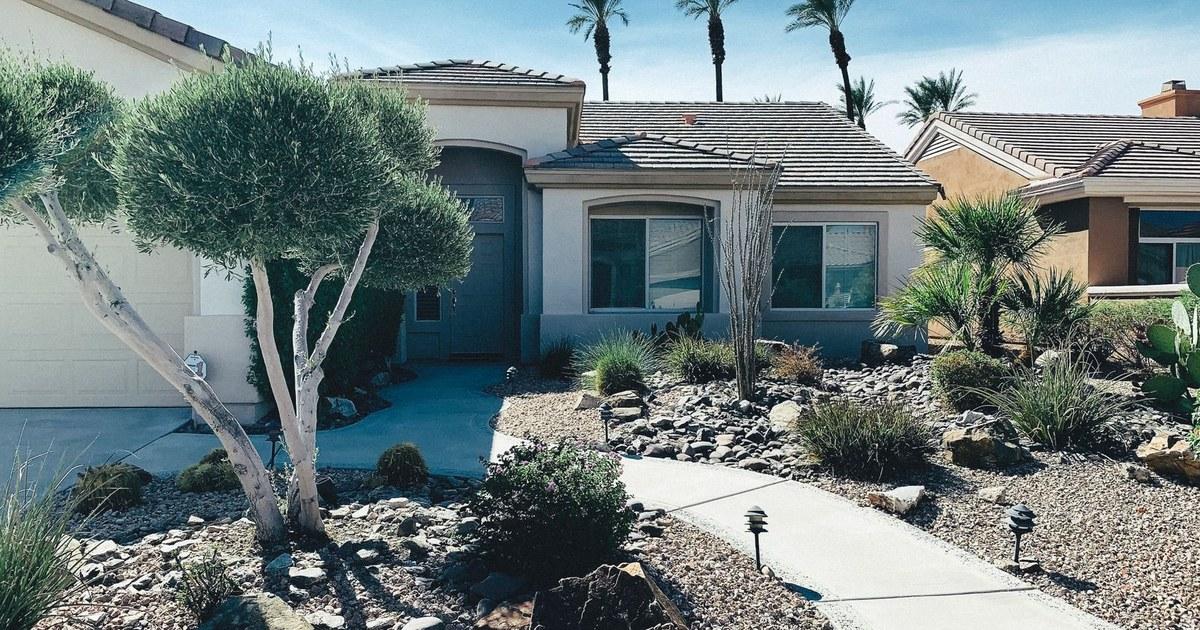 Single-story stucco home with desert landscaping and a concrete driveway
