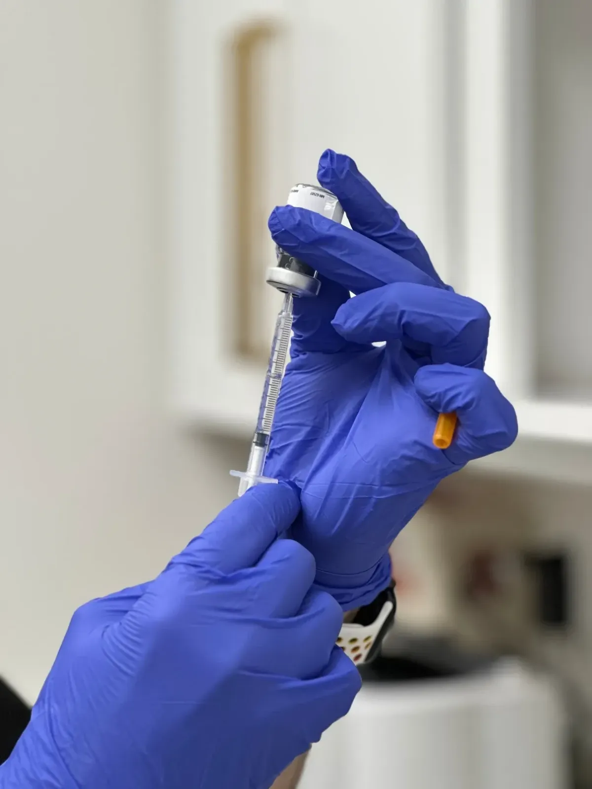 A provider pulls neurotoxin from vial.