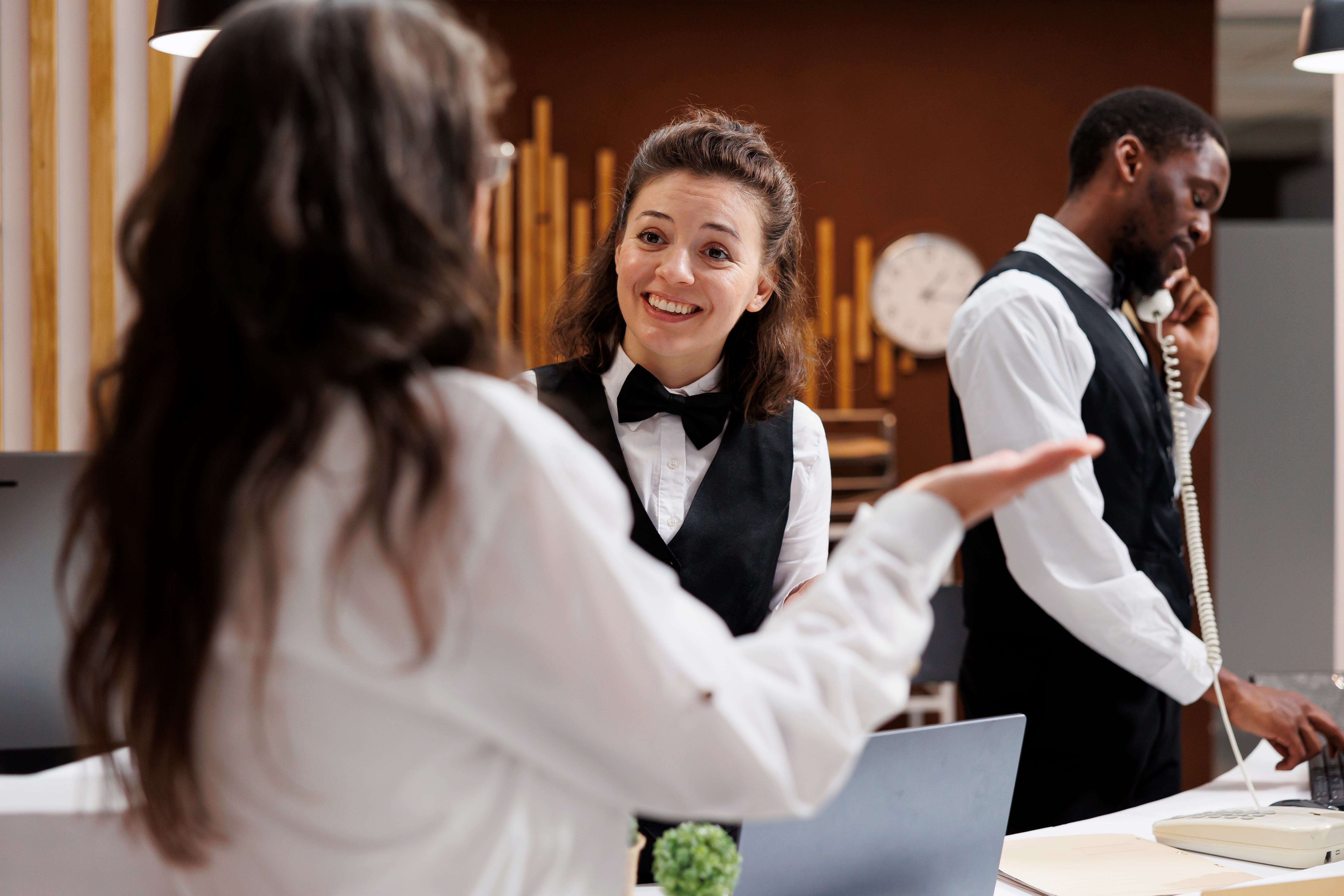 Housekeeping supervisor training a room attendant in a hotel hallway