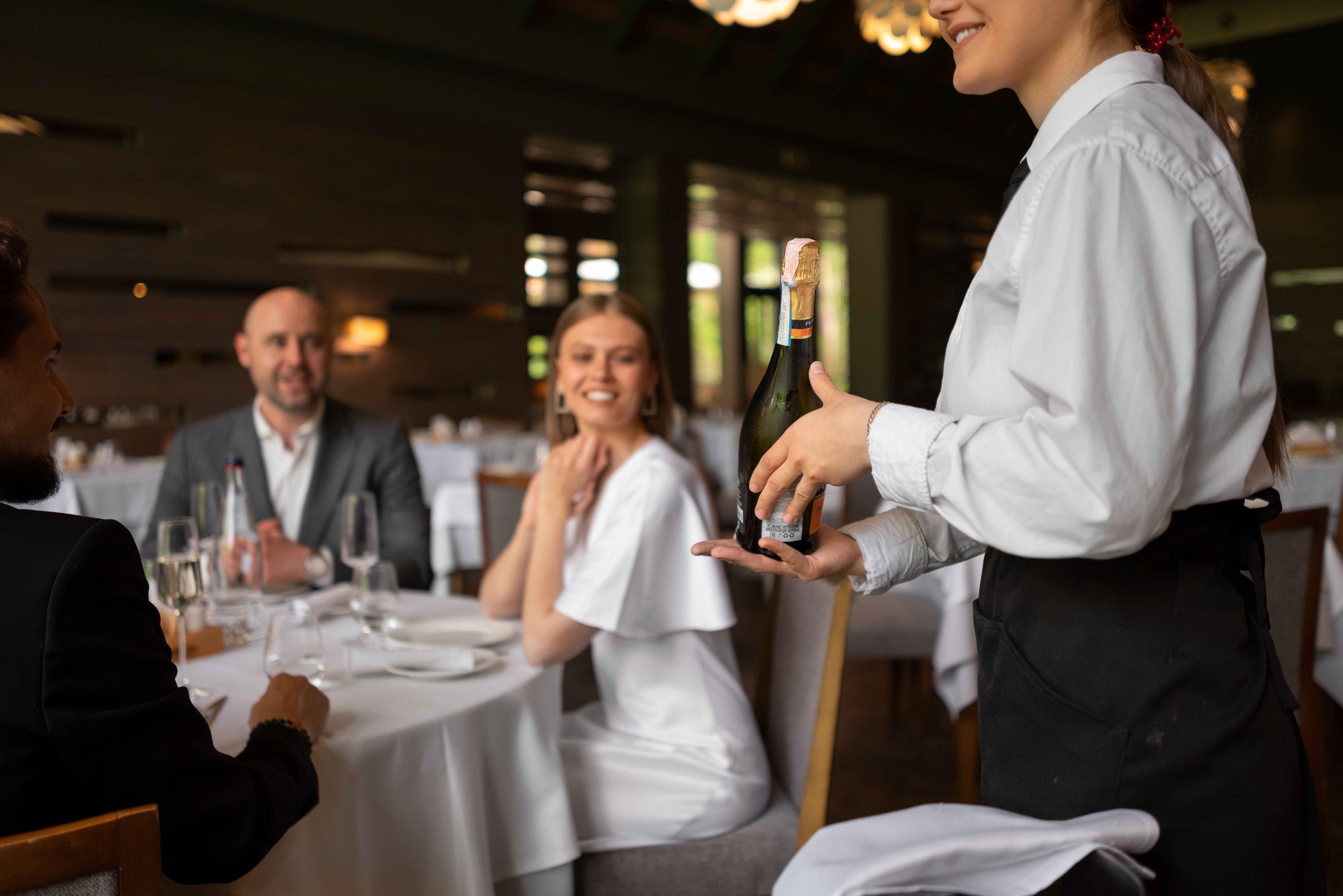 Banquet servers setting up a formal event dining room in a hotel