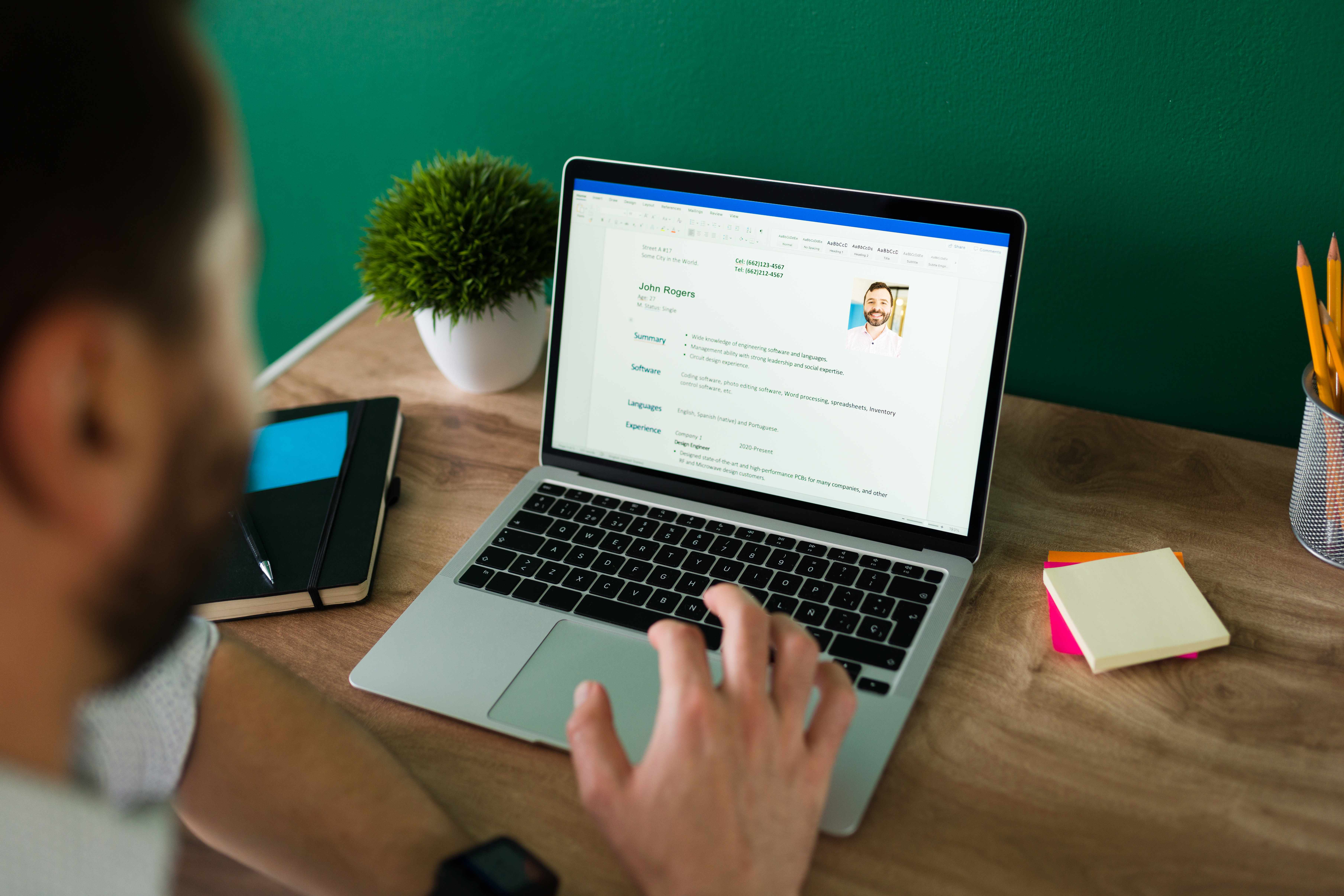 Person writing a resume on a laptop applying for a hotel housekeeping job