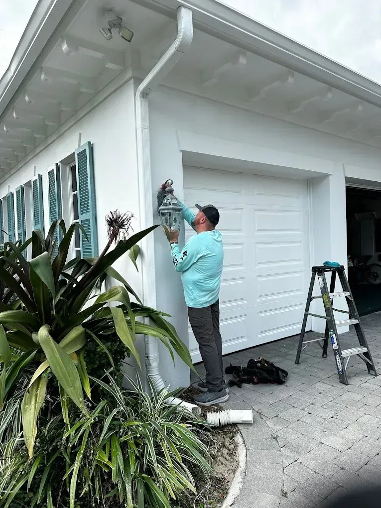 Bee Electrical Contracting electrician repairing outdoor light fixture at a home in Port St. Lucie, FL