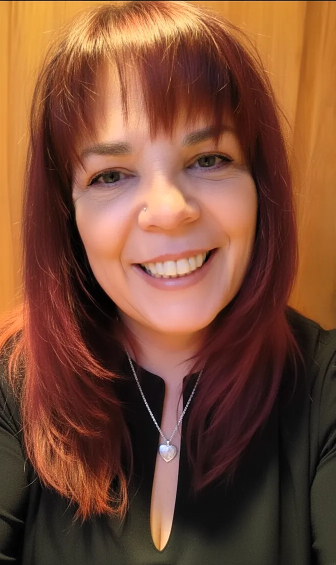 Robyn Bennett, certified business strategist and tech expert, smiling in a black blouse with a silver heart necklace.