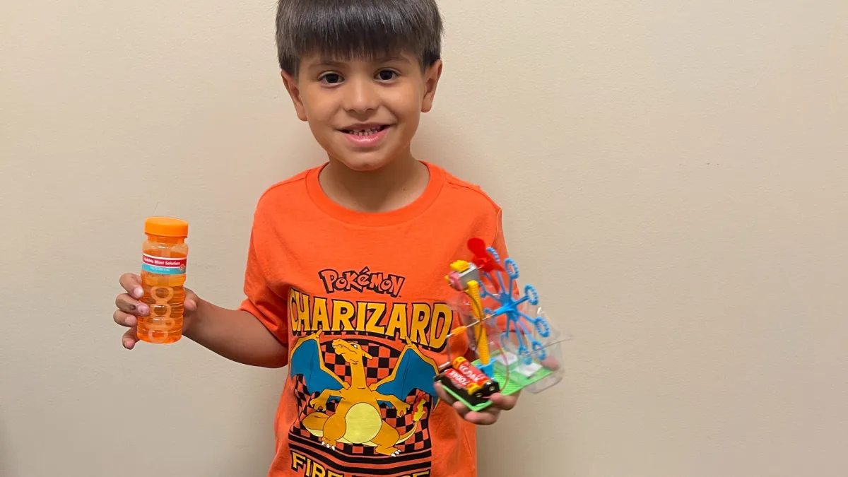Boy picks paper out of different colored liquids