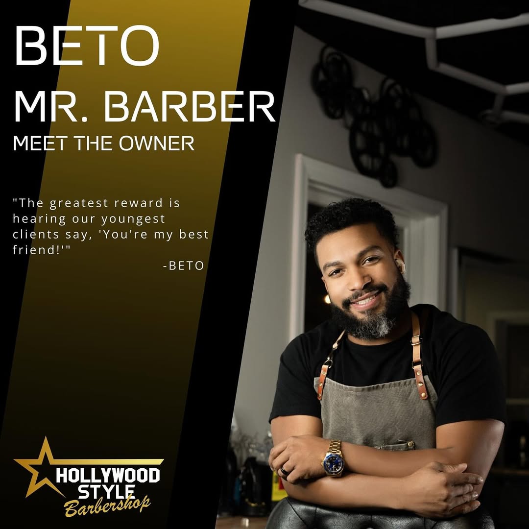 Barber adjusting client's collar in front of mirror with golden light