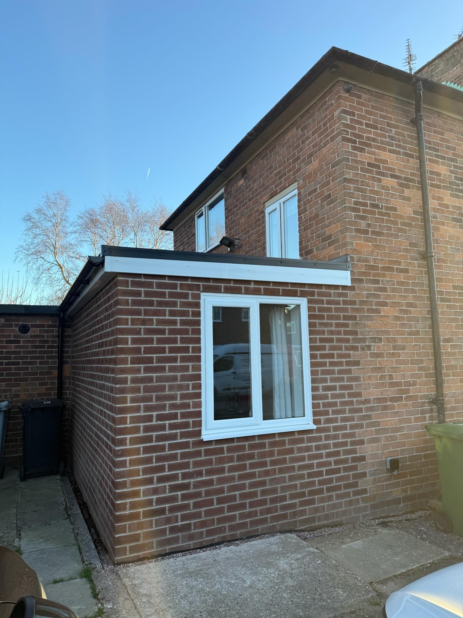 Completed side extension to a semi detached house in Wilmslow, creating an additional bedroom with matching brickwork and a new window.