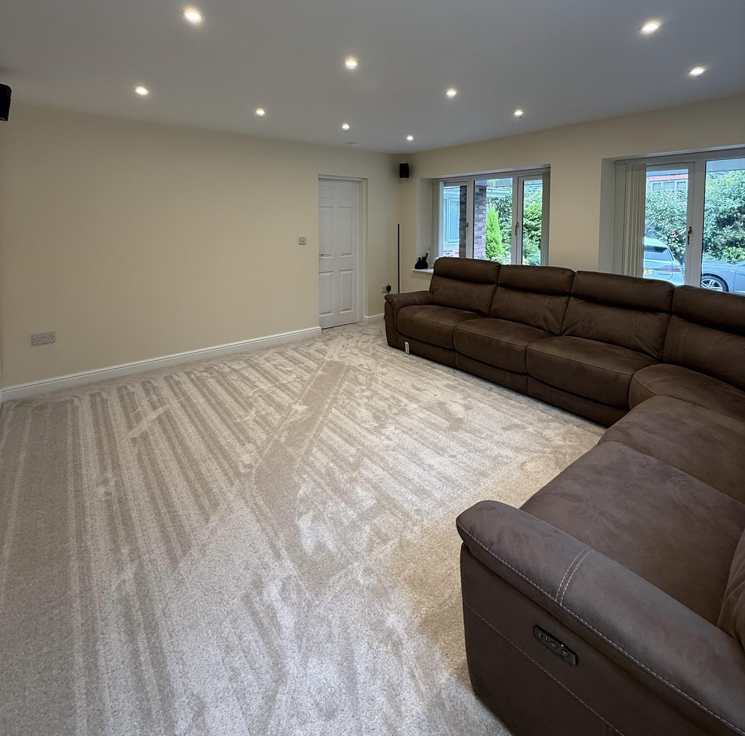 Attached double garage conversion in Rochdale transformed into a spacious living room with new windows.
