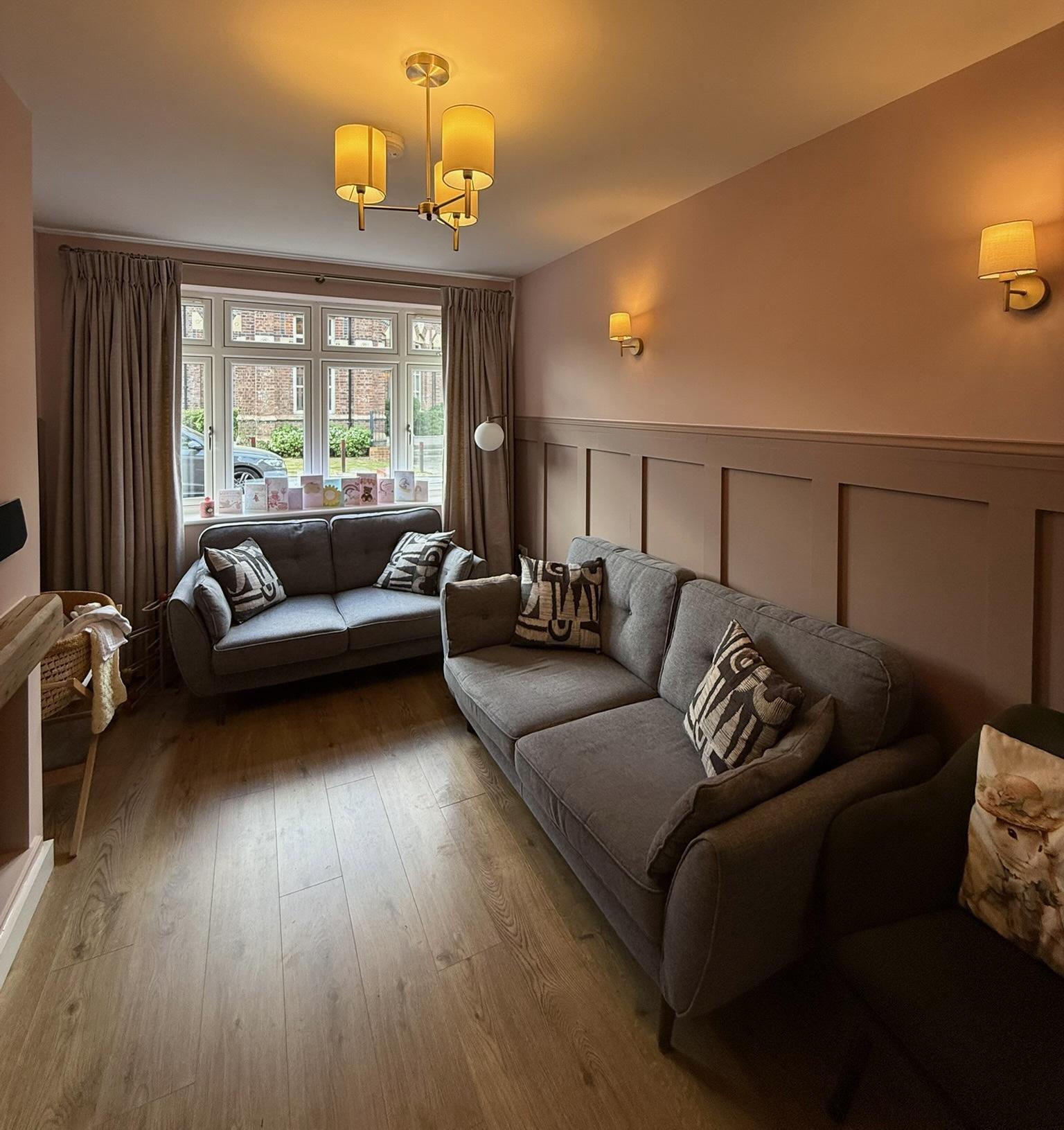 Completed garage conversion in Cheadle transformed into a second living room, showing the finished result after the existing garage structure was assessed for conversion.