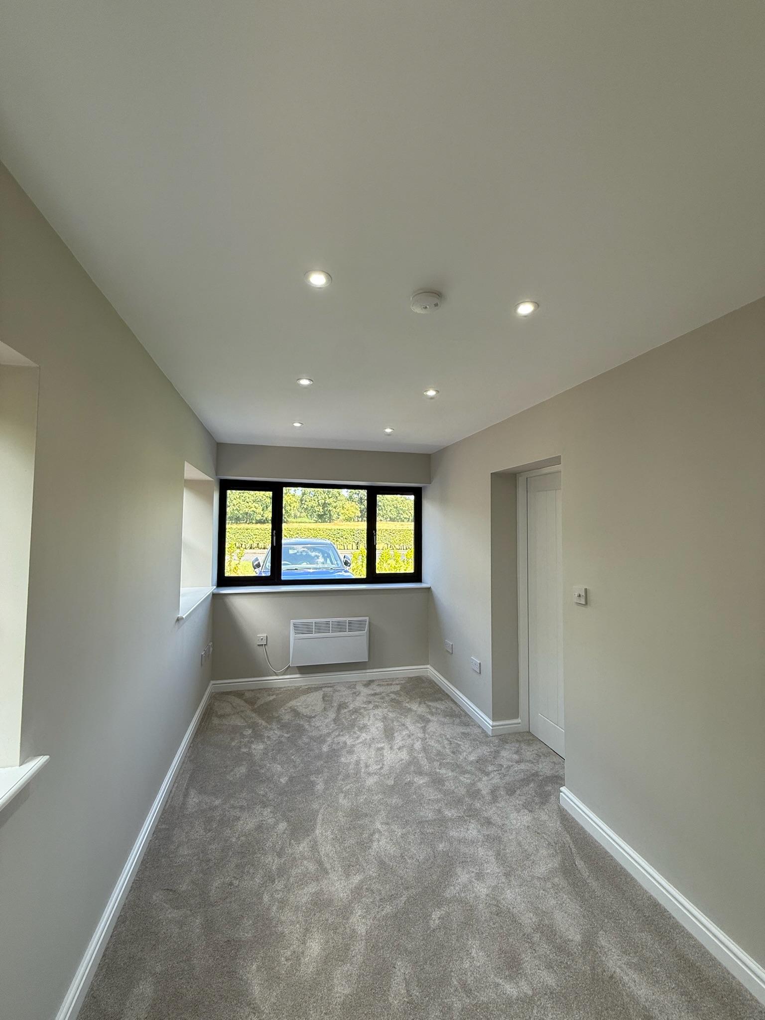 Finished garage conversion with soft grey carpet, showing how flooring can help create a warm and comfortable new living space.