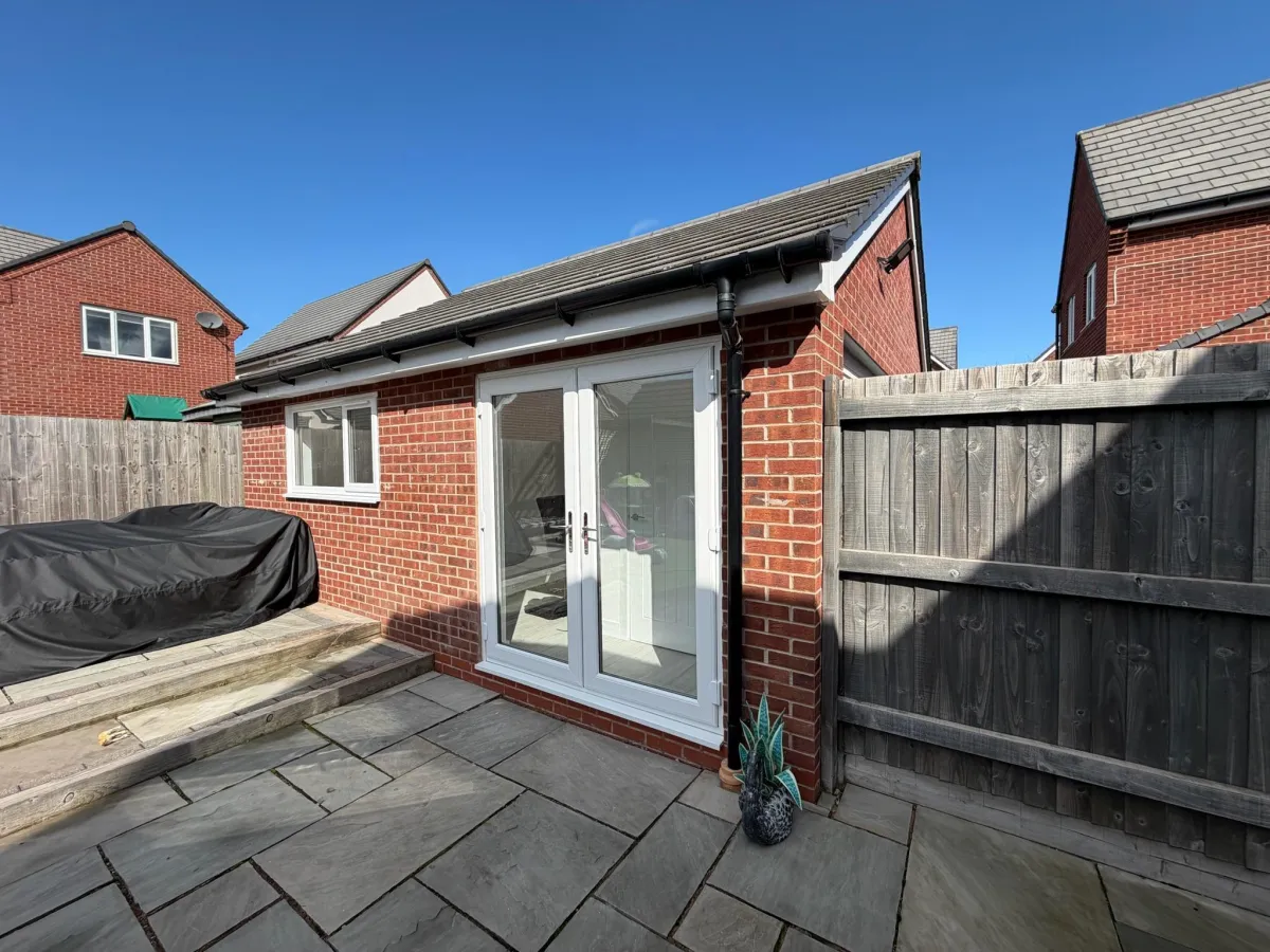 Detached garage conversion with French doors and a finished floor, showing how garage floor levels and external thresholds are considered during conversion.