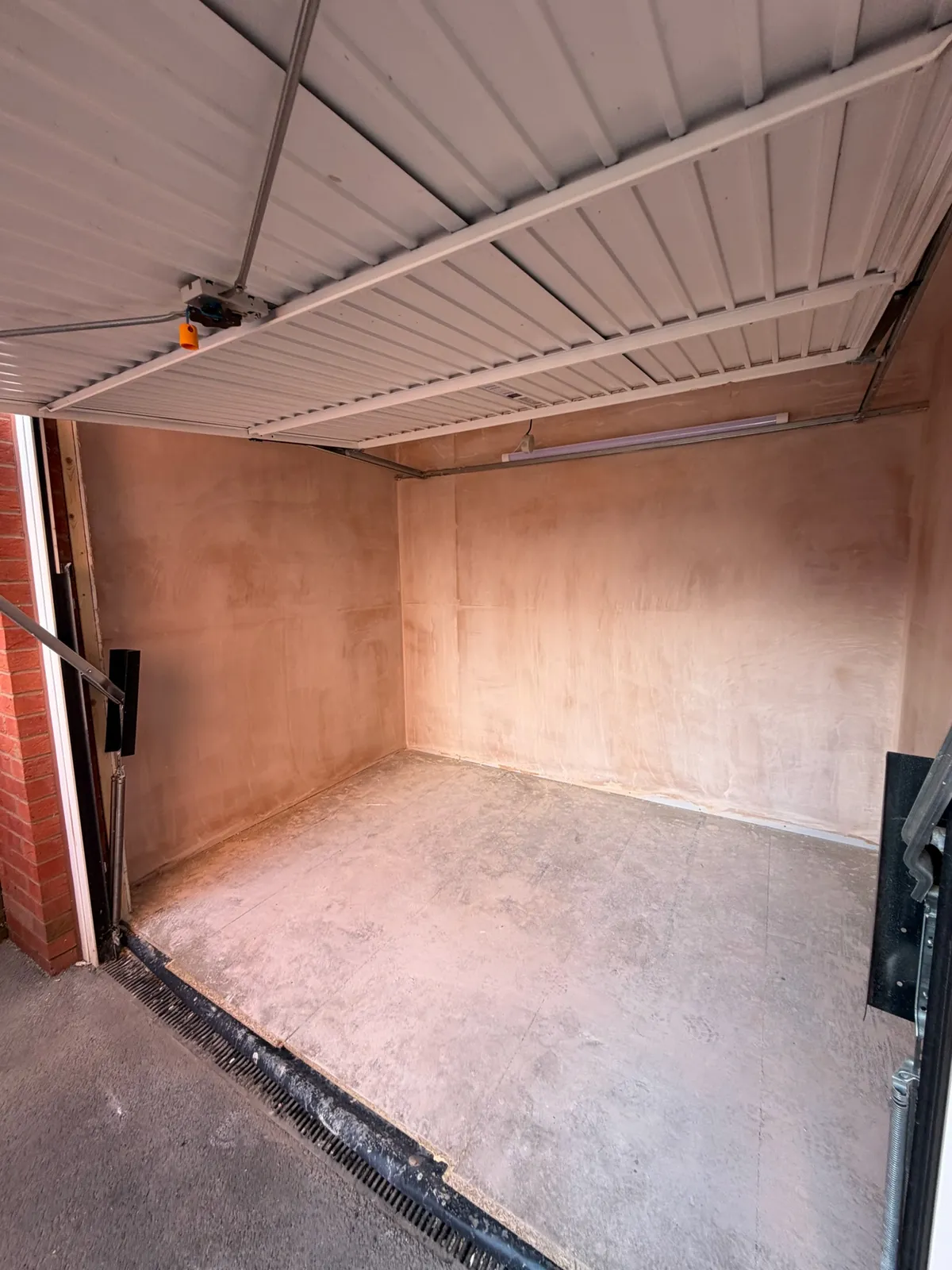 Storage area retained behind the original garage door as part of a single garage conversion in Atherton, with the main garage transformed into an additional room.