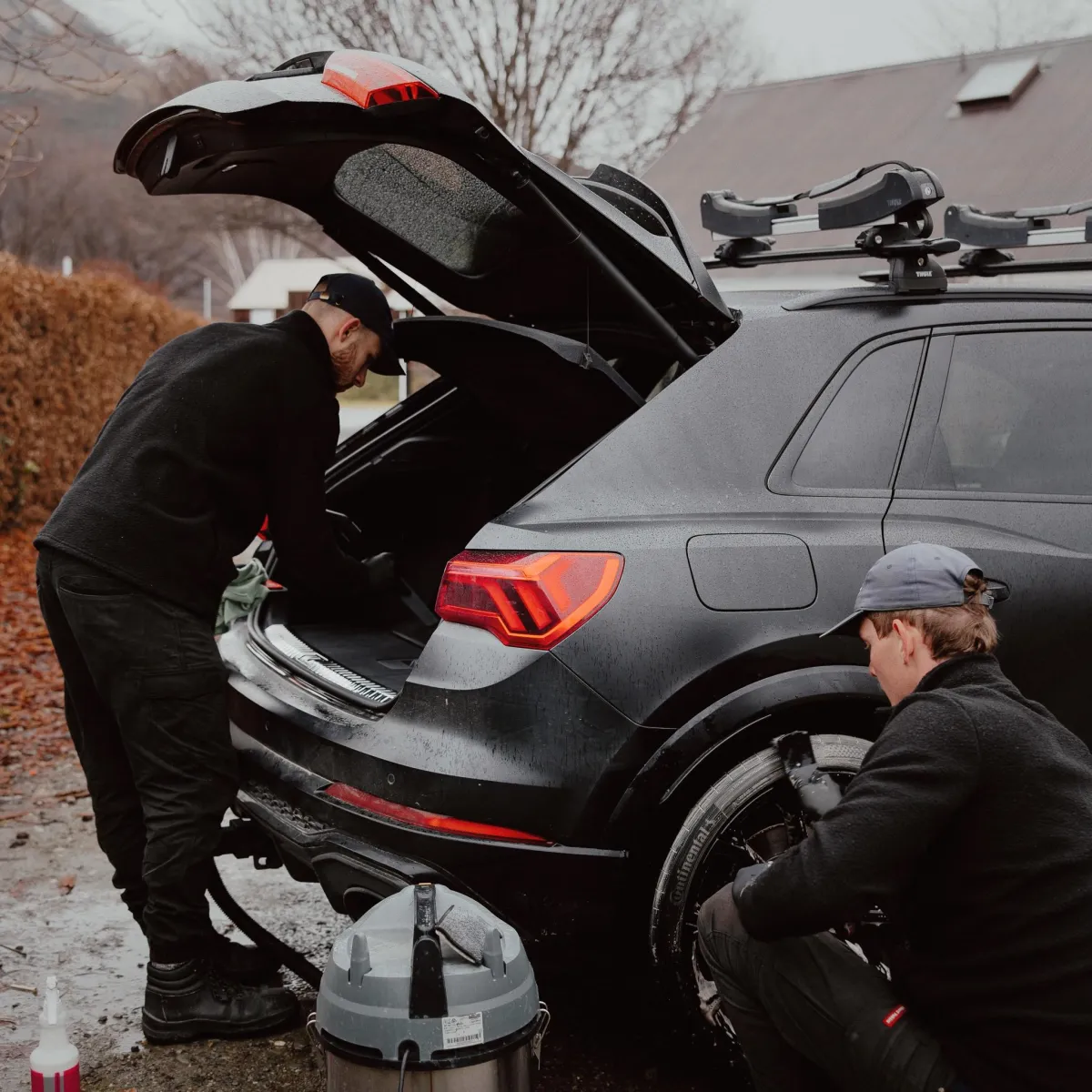 Elliot vacuuming car boot while Mason cleans wheel, mobile car detailing in Queenstown