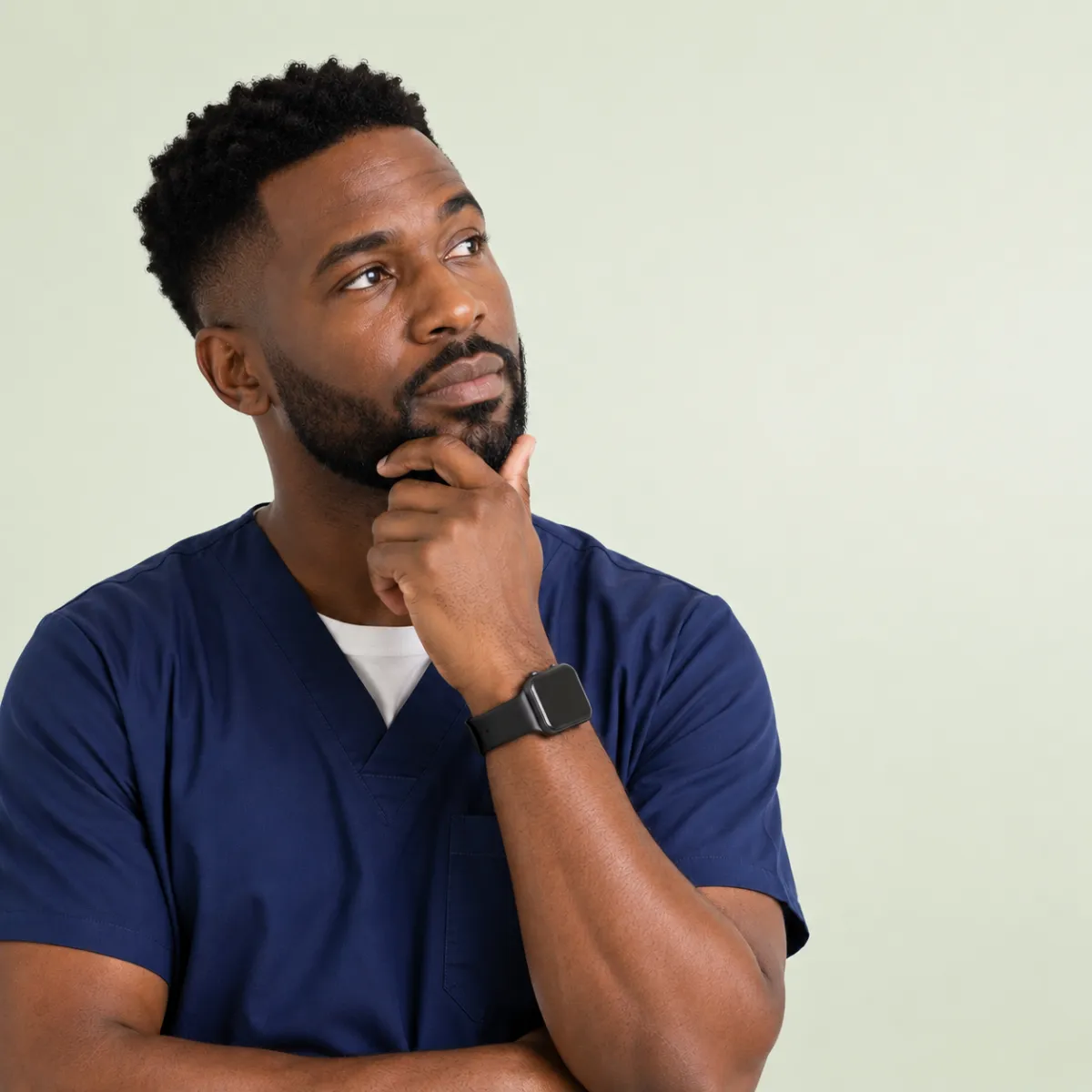 Healthcare professional in scrubs reflecting on clinical decisions or workflow tasks, symbolizing decision‑making in patient care.