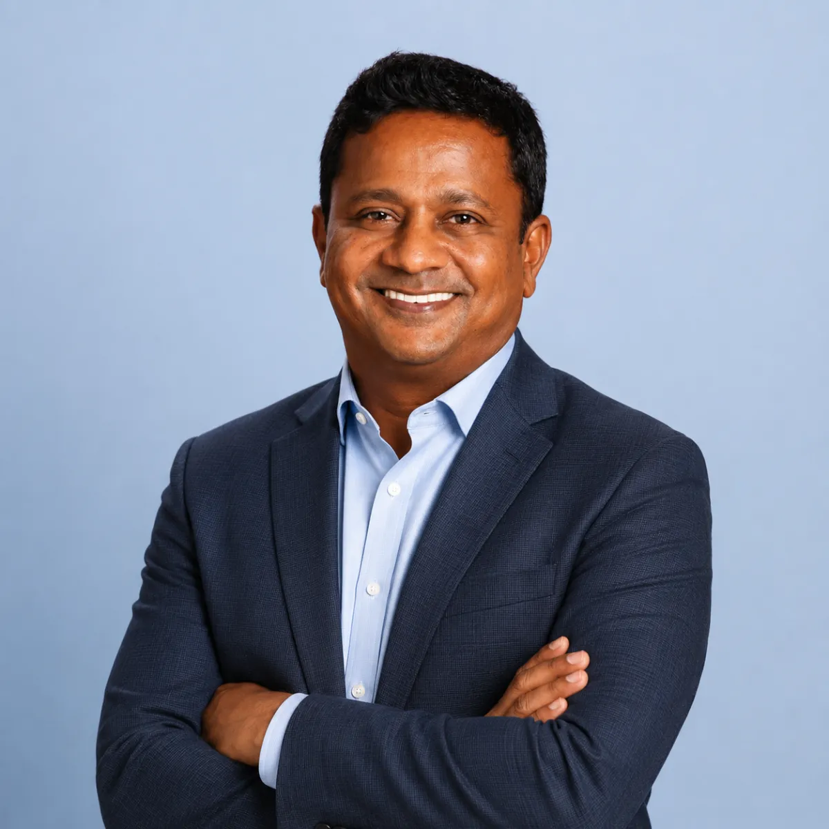 Dinesh Selvakumar, founder of Complete Intake, photographed in a professional portrait with arms crossed, representing leadership in healthcare workflow automation.