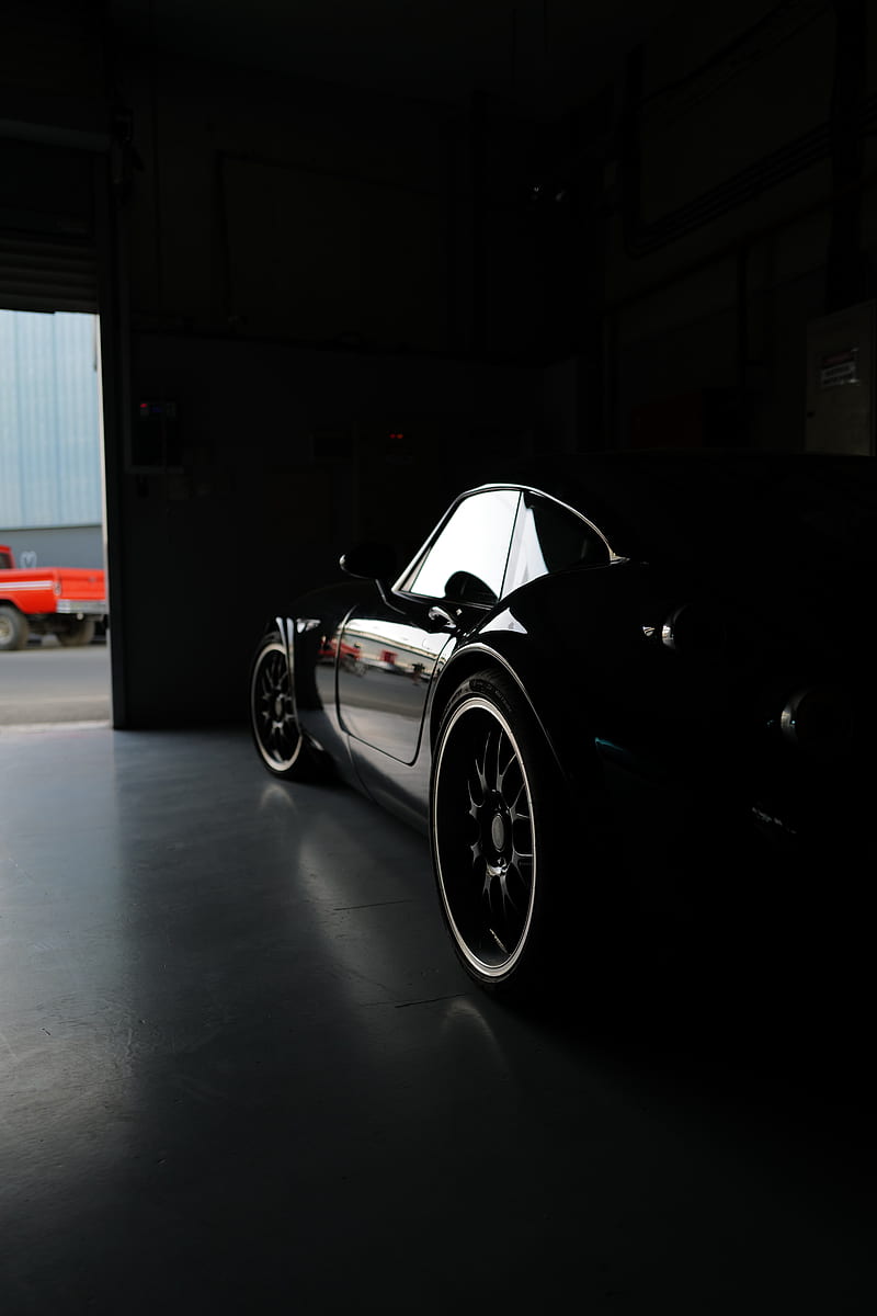 a man polishing the side of a green sports car
