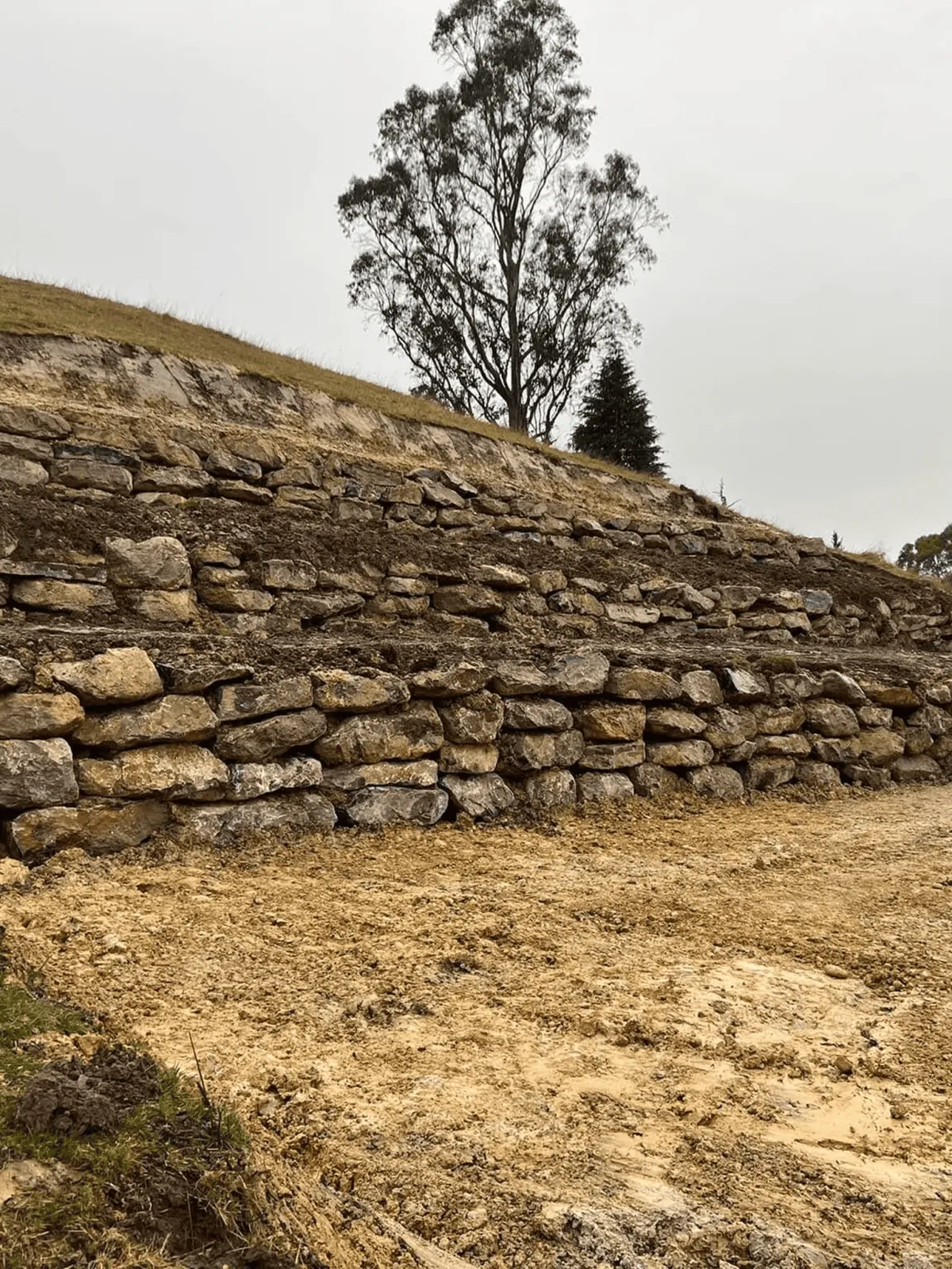 Stone rock retaining wall on sloping rural section Tasman