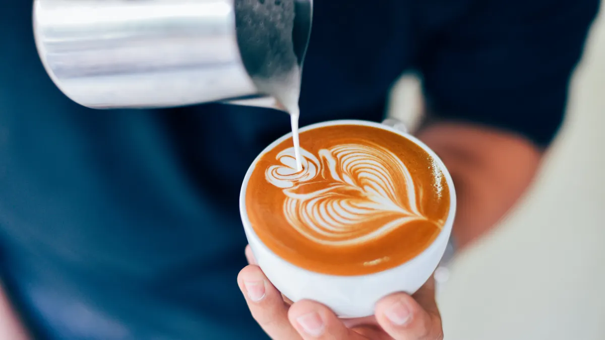 cup of coffee near MacBook Pro