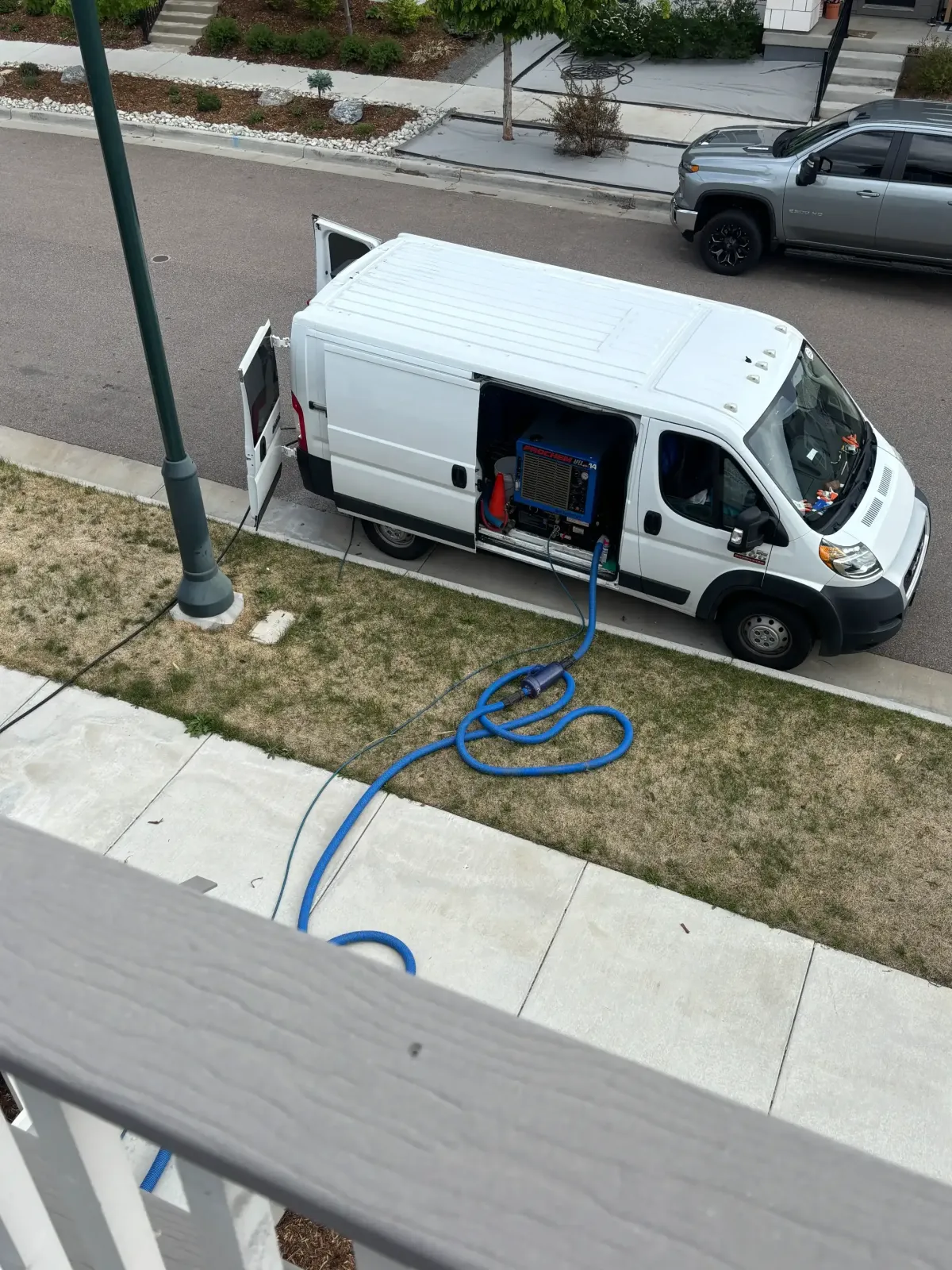 Carpet cleaning van parked on a compact residential street in Englewood, CO near Broadway corridor