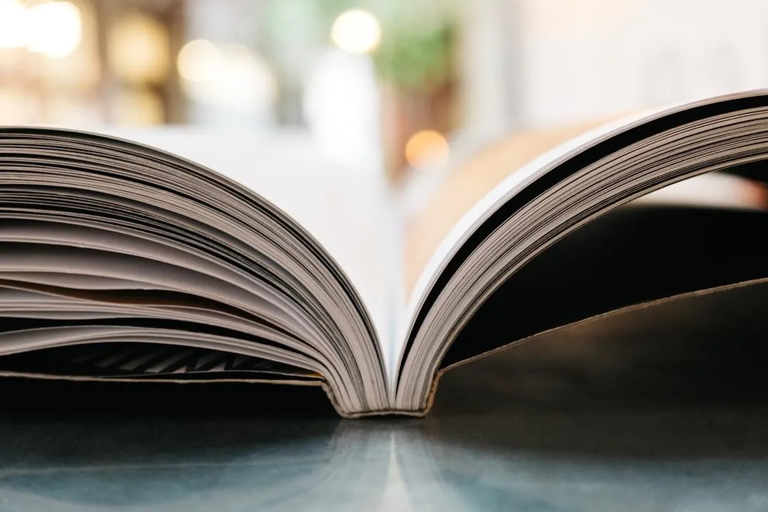 An open book is resting on a surface with its pages slightly fanned out, viewed from a low angle.