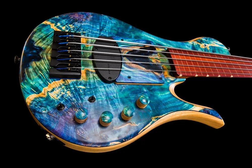 Bass guitar with colorful blue and green top on black background