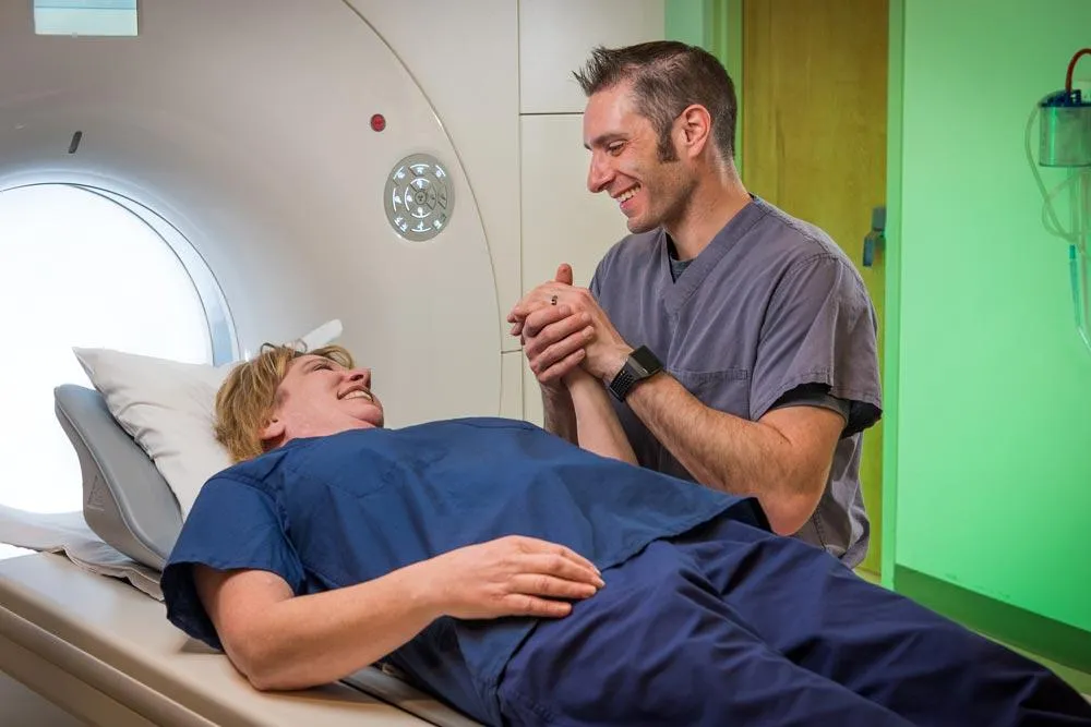 Medical professional holding woman's hand before MRI
