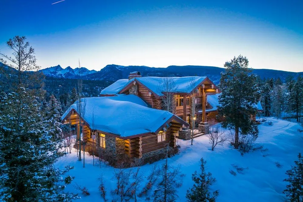 Log home in winter at sunrise before sky replacement