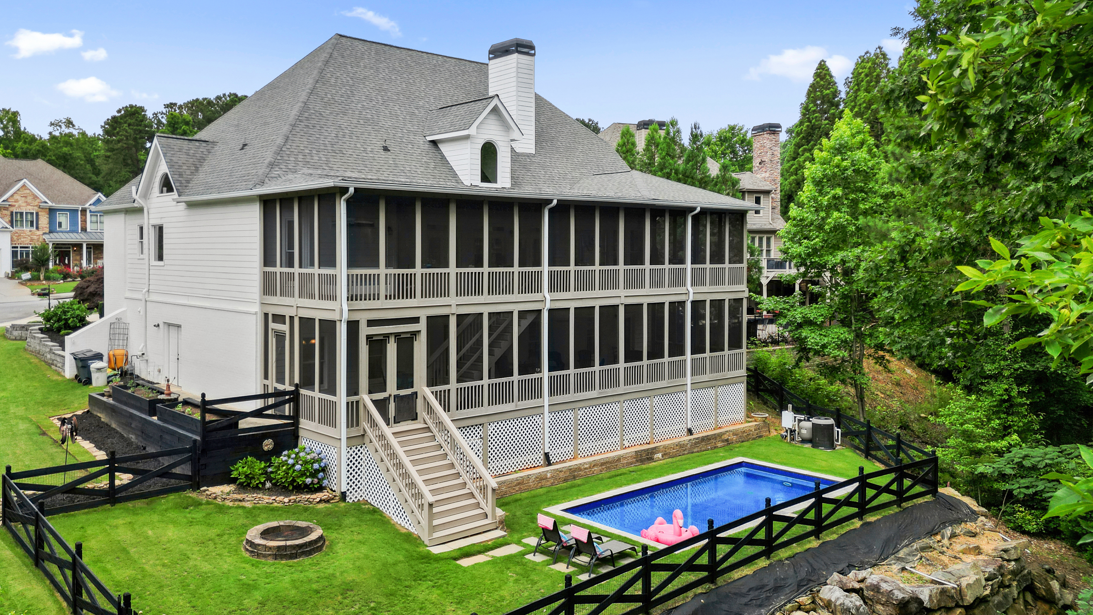 A panoramic view of a modern luxury home in Acworth at sunset, featuring expansive glass walls, a glowing pool, and lush landscaping. The scene includes a diverse couple admiring the property, with warm lighting and elegant architectural lines, evoking exclusivity and sophistication.