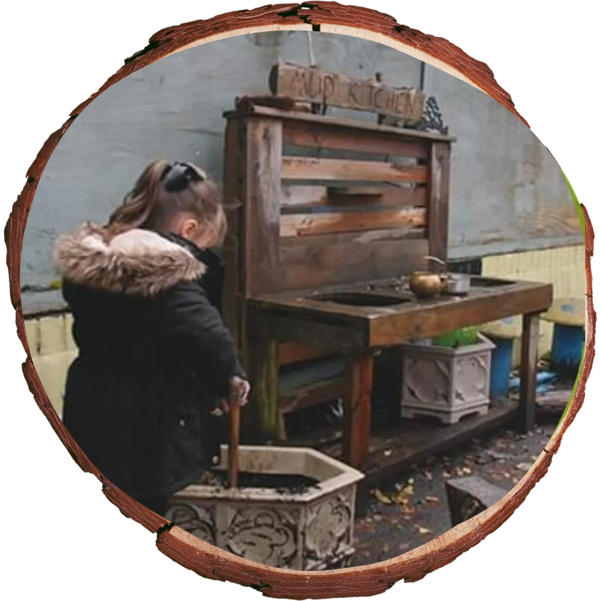 little girl playing outside in mud kitchen