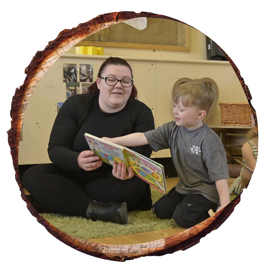 teacher sat with child reading a book