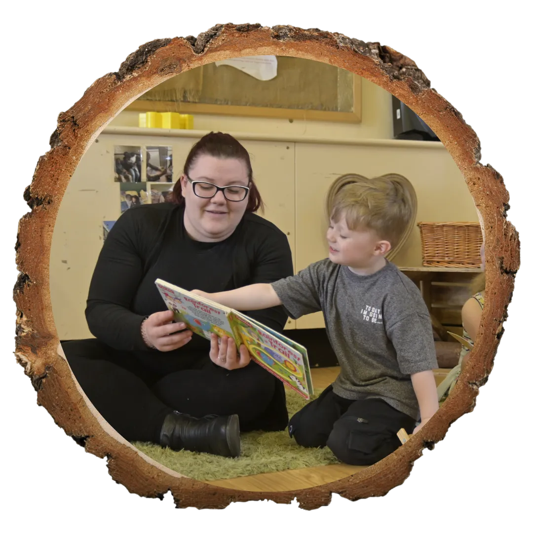 teacher sat with child reading a book