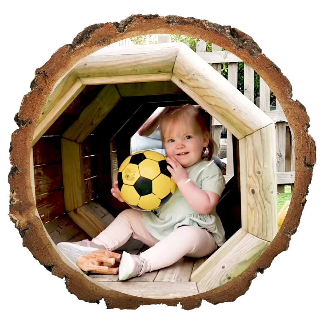 toddler little girl playing in wooden tunnel 