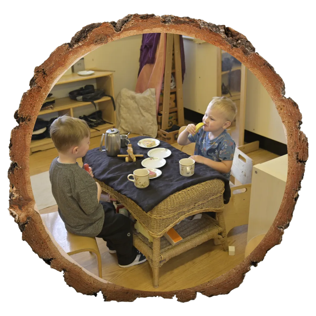 two children sat at a table having a tea party