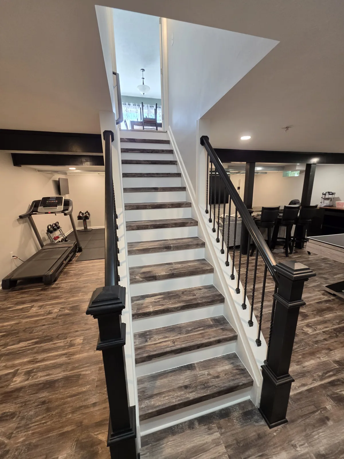 Finished basement family room with built-in shelving and warm lighting