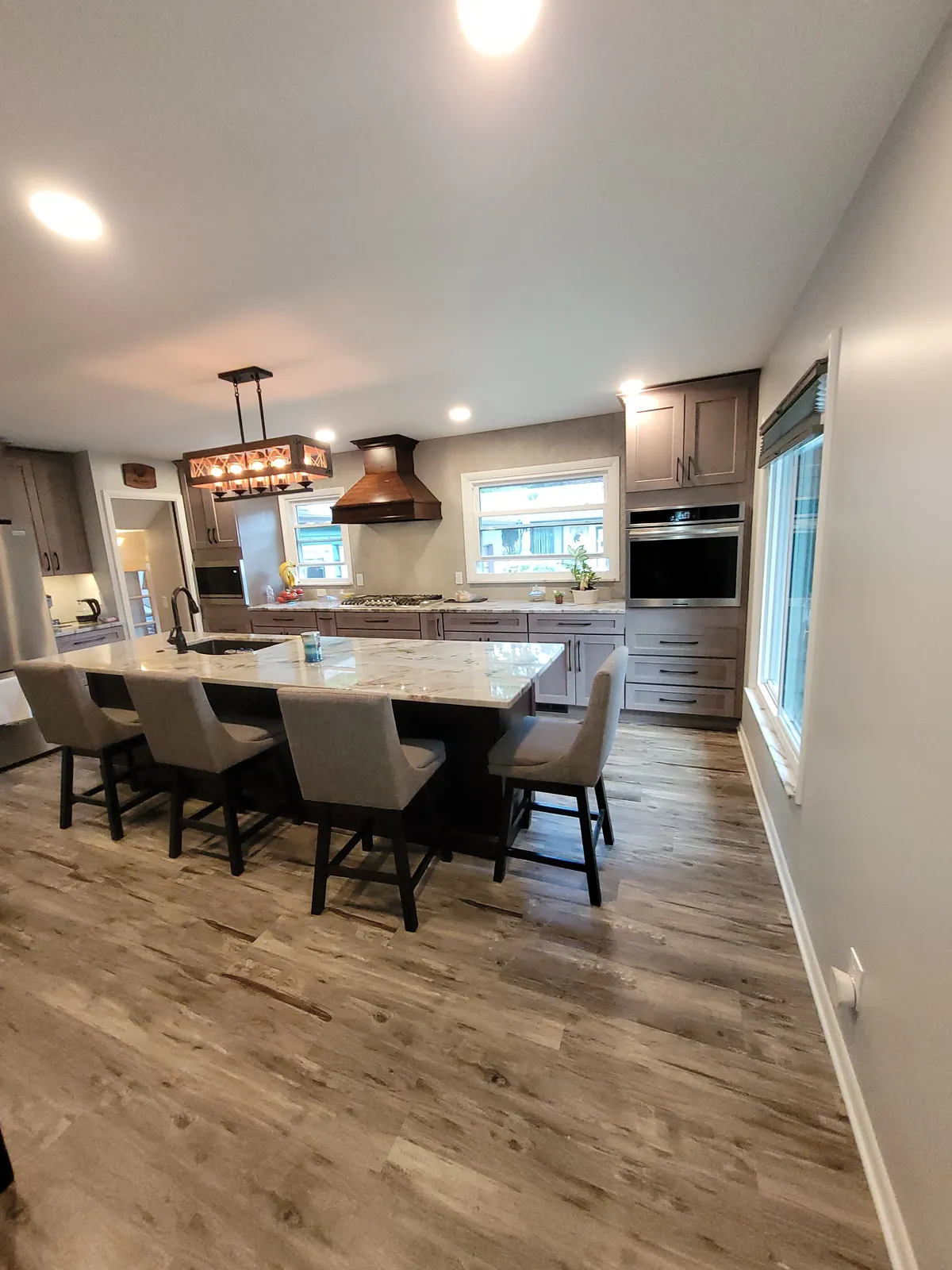 Remodeled kitchen with white cabinetry, a wood island, and pendant lighting