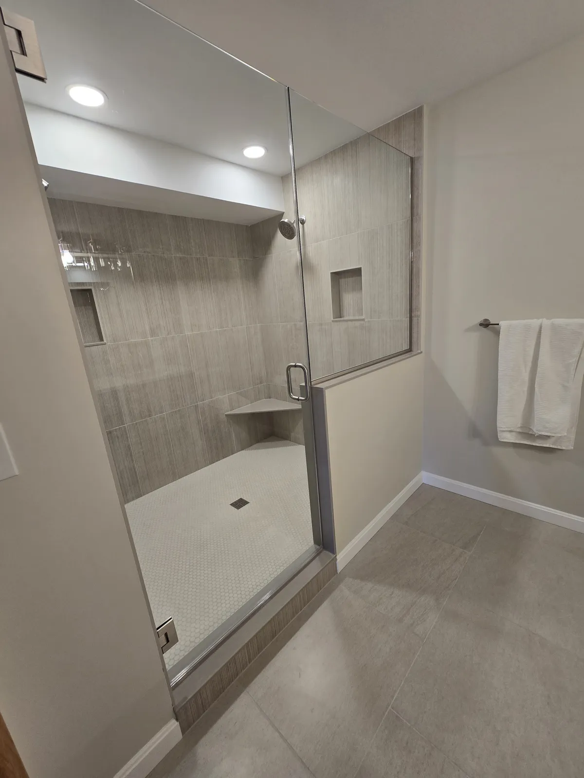 Remodeled bathroom with a walk-in shower, double vanity, and natural light