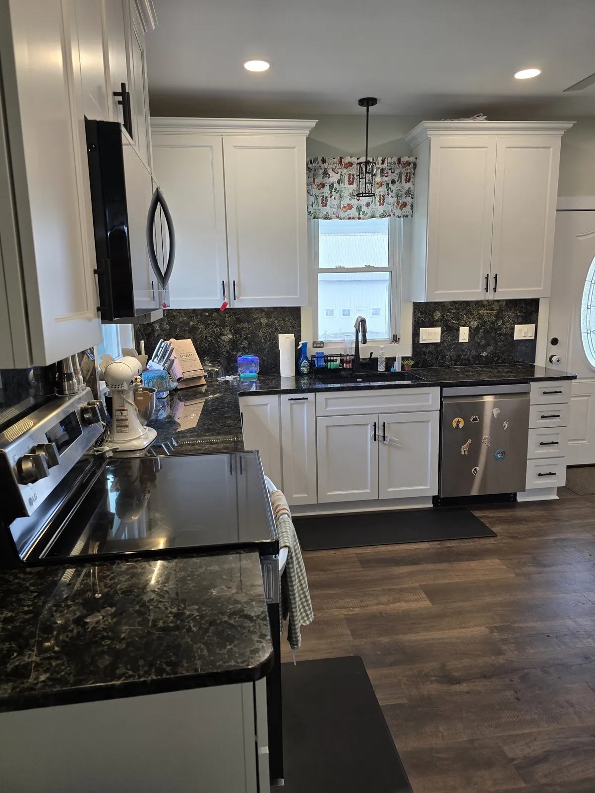 Remodeled kitchen with white cabinetry and a wood island